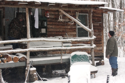 Team members inspect the front porch of the cabin. (Photo: Alex Diaz).