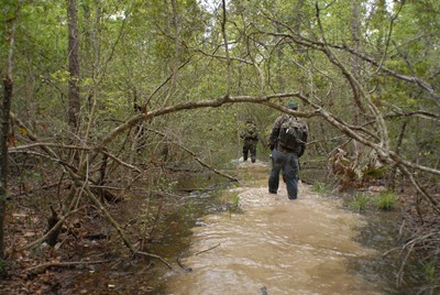 Daryl Colyer leads Travis Lawrence and the rest of the team through a creek in Area Y to avoid the nearly impenetrable thicket to either side.